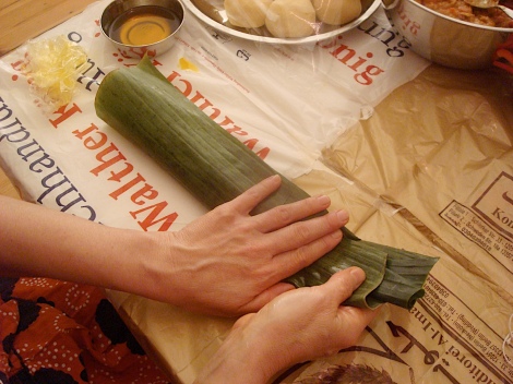 wrapping the banana leaves around the dough and stew